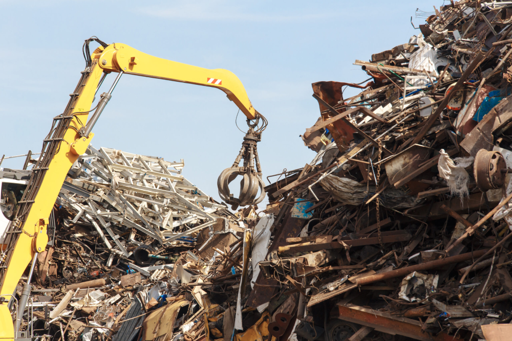 Image of a crane lifting metals at a recycling center
